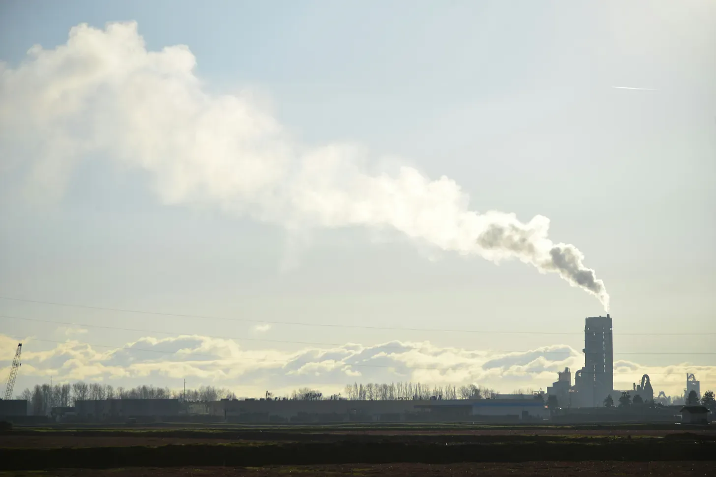 An industrial stack venting against a winter sky